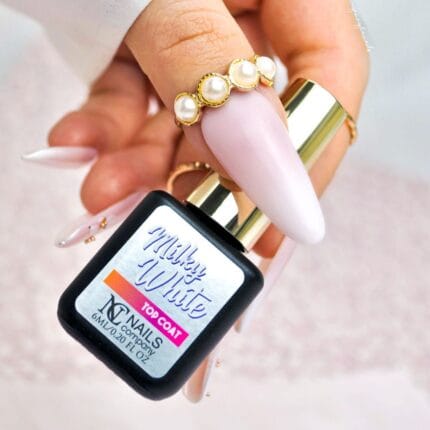Nails Company Top Milky White 11 ml – czarna buteleczka Milky White Top Coat w dłoni z różowym manicure