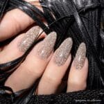 Nails Company Lakier Hybrydowy 102 Show Glow 6 ml – beżowo-złoty brokatowy swatch na migdałowych paznokciach