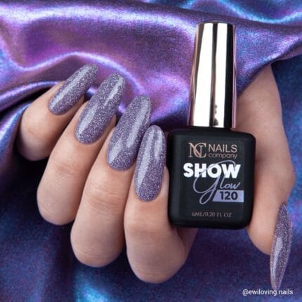 Nails Company Lakier Hybrydowy 120 Show Glow 6 ml - dłoń trzymająca butelkę 6 ml, paznokcie pokryte fioletowo-szarym brokatem