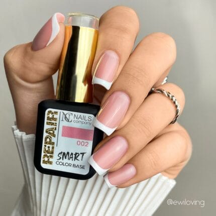 Nails Company Smart Color Base 002 11 ml – french na dłoni trzymającej czarną buteleczkę z etykietą 002