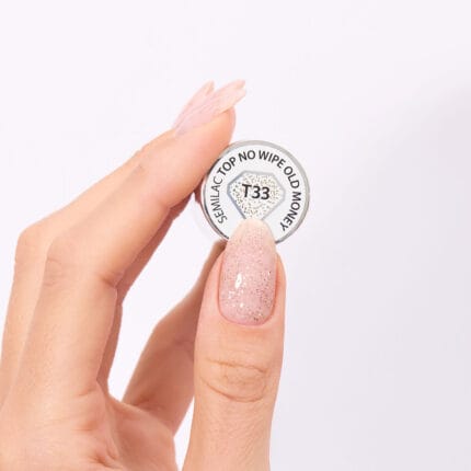 Semilac T33 Top No Wipe Old Money 7 ml – dlon trzymajaca sloiczek z etykieta, paznokcie z brokatem