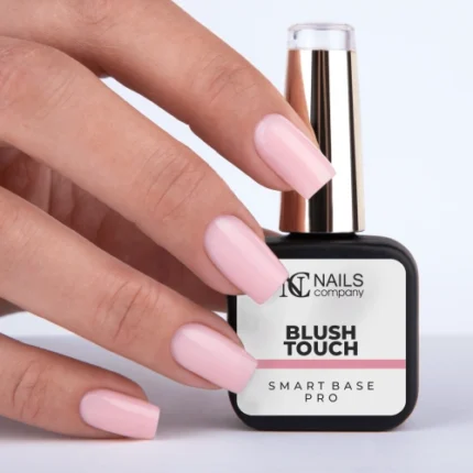 Nails Company Smart Base Pro - butelka Blush Touch 11 ml trzymana w dłoni z pomalowanymi różowymi paznokciami